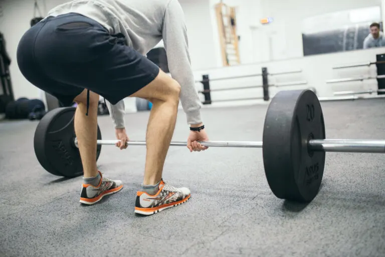 fit young man doing deadlift exercise in gym