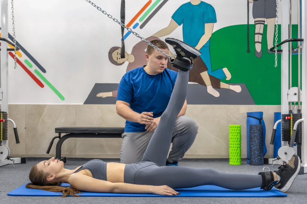 doctor patient doing suspended leg raise movement therapy